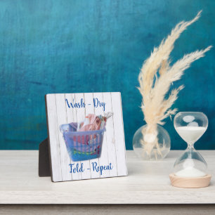 Kleurrijk gevouwen wasgoed op hanen in een blauwe  fotoplaat