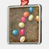 Kleurrijke gekleurde eieren in de tuin, paaseieren metalen ornament (Links)