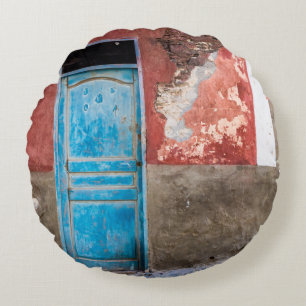 Kleurrijke muur met blauwe deur rond kussen