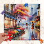 Kleurrijke regenachtige dag in de stad Waterverf P Legpuzzel<br><div class="desc">Puzzel met een waterverf schilderij van een meisje met een paraplu lopen langs een bloemenwinkel op een regenachtige dag in de stad.</div>