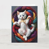 Knuffelwit katje speelt met rollen garen op deken kaart (Voorkant)