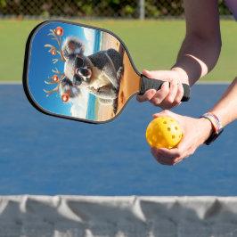 Koala op het strand met een gewei en kralen pickleball paddle