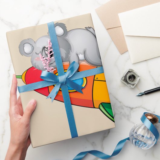 Koala slapen op kleurrijke raket cadeaupapier