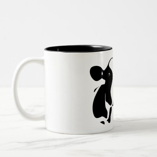 Koe boven tweekleurige koffiemok (Links)