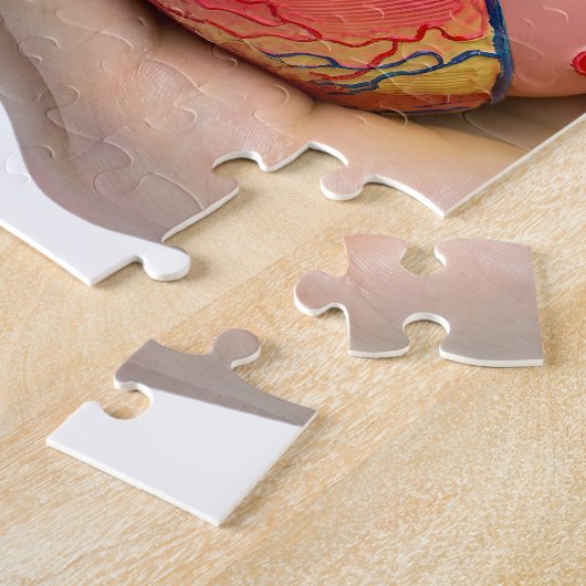 Kunstmatig menselijk hartmodel in de hand legpuzzel (Zijkant)