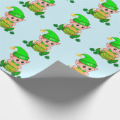 Kute green elf met een pot goud op lichtblauw cadeaupapier (Hoek)