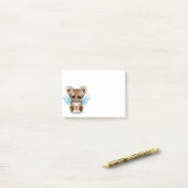 Kute tijgerkubus met zachte vleugels op blauw post-it® notes (Op bureau)