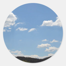 Landschap met groene heuvels, bomen en wolken ronde sticker