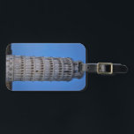 Leaning Tower at Dusk Bagagelabel<br><div class="desc">This captivating photograph showcases the iconic Leaning Tower of Pisa standing elegantly against a deep blue twilight sky in Pisa. The historic marble tower, famous for its unmistakable tilt, is beautifully illuminated, highlighting its intricate Romanesque arches and layered columns. The soft evening light creates a striking contrast between the glowing...</div>