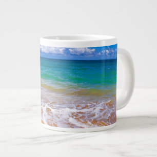 Leeg strand en blauwe wateren grote koffiekop