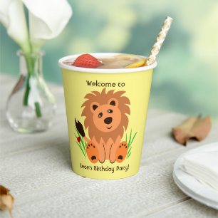 Leuke leeuw in het gras met lieveheersbeestje, kin papieren bekers