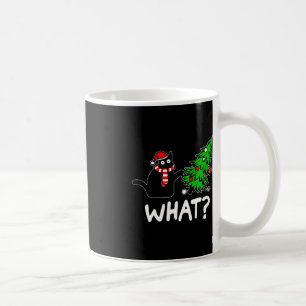 Leuke ondeugende zwarte kat duwen kerstboom over koffiemok