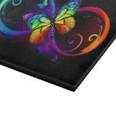 Levendige oneindigheid met regenboogvlinder op zwa snijplank (Hoek)