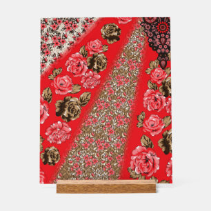 Levendige rode stof met ingewikkelde bloemen en acryl bord