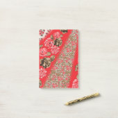 Levendige rode stof met ingewikkelde bloemen en post-it® notes (Op bureau)