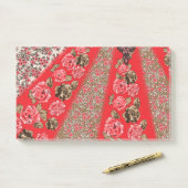 Levendige rode stof met ingewikkelde bloemen en post-it® notes (Op bureau)