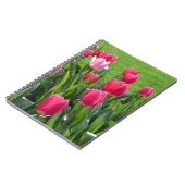 Levendige roze tulpbloemen en groene bladeren. notitieboek (Linkerzijde)