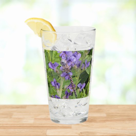 Libel met blauwe ogen op paarse bloemen glas