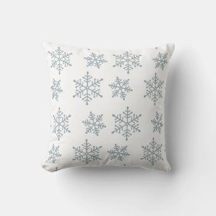 Lichtblauwe sneeuwvlokken op wit kussen