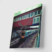 Lichtblauwe trein, onder de brug vierkante klok (Hoek)