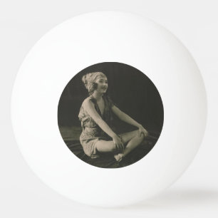 Lief arm meisje zit met gekruiste benen pingpongbal