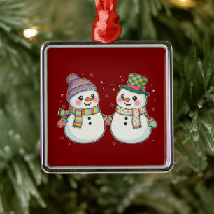 Lief paar sneeuwmannen uit een cartoon houdt elkaa metalen ornament