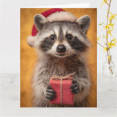 Lief wasbeerhondje in een kerstmuts houdt een cade kaart (Gele Bloem)