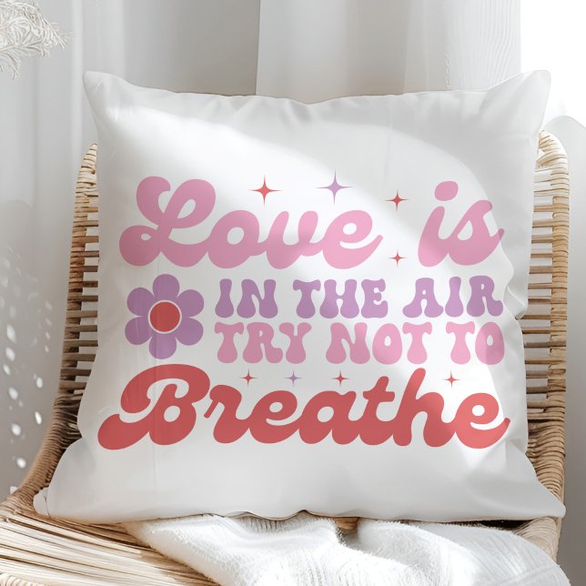 Liefde is in de Air Funny Anti Valentine Kussen (Love is in the Air Funny Anti Valentine Throw Pillow on a sunny rattan chair.)