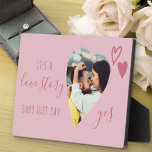 Liefde verhaal zeggen ja Roze Voorstel Foto Fotoplaat<br><div class="desc">Een bordje met een romantisch hart gevormd door een foto. Het is geletterd met "het is een liefdesverhaal, baby zegt gewoon ja" in elegant script en gedecoreerd met roze liefdesharten. Perfecte steun en hoede voor je huwelijksvoorstel en de aankondiging van het verloving. Het ontwerp is in roze tinten maar u...</div>