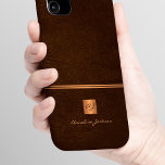 Luxe elegante gouden glitter bruin monogrammed iPhone 16 hoesje<br><div class="desc">Classy exclusieve uitziende kantoor of persoonlijke monogrammed telefoonhoesje met een faux koperen metallic gouden glitter vierkant met uw monogram naam initialen en een sprankelende streep over een stijlvolle donkerbruine faux lederen achtergrond. Geschikt voor kleine bedrijven, zakelijke of onafhankelijke zakelijke professionals, personal branding of stylisten specialisten, make-up artiesten of schoonheidssalons, boetiek...</div>