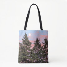 Maansopkomst bij zonsondergang met roze wolken