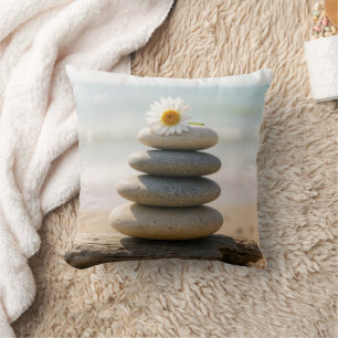 Madeliefje op een strandstenen cairn met drijfhout kussen
