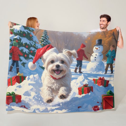 Maltezer hond rent in de sneeuw met kerstmuts fleece deken (In situ)