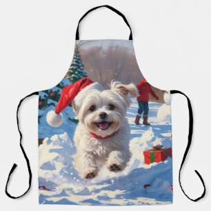 Maltezer hond rent in de sneeuw met kerstmuts schort
