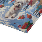 Maltezer hond rent in de sneeuw met kerstmuts snijplank (Hoek)