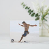 Man dat voetbal schopt op het strand briefkaart (Staand voorkant)