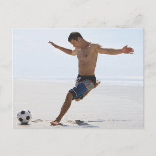 Man dat voetbal schopt op het strand briefkaart