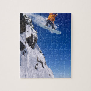 Man op een snowboard die van een richel springt bi legpuzzel