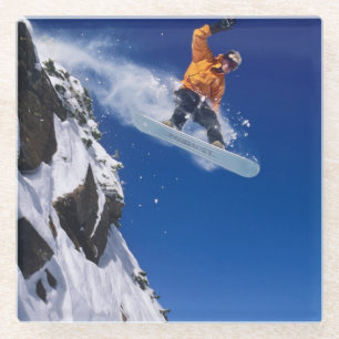 Man op een snowboard die van een richel springt glazen onderzetter