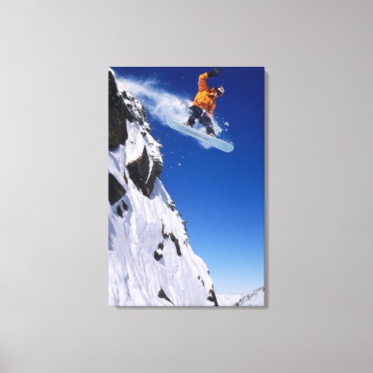 Man op een snowboard springend van een richel bij canvas afdruk (Voorkant)