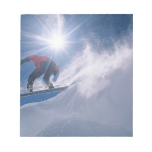 Man springt van een grote cornince af op een snowb notitieblok
