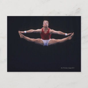 Mannelijke gymnast die op de vloer werkt briefkaart