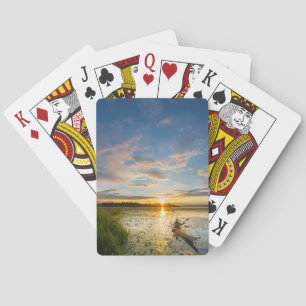 Mannelijke kanoër peddelt zeekajak op stilstaand w pokerkaarten