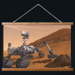 Mars Science Laboratory Curiosity Rover. Hangend Wandkleed<br><div class="desc">Het concept van Mars Science Laboratory Curiosity rover is een mobiele robot die het cadeau van Mars onderzoekt. In dit afbeelding onderzoekt de rover een rots op Mars met een set gereedschappen aan het uiteinde van de arm van de rover, die ongeveer 7 voet uitstrekt. Twee instrumenten op de arm...</div>