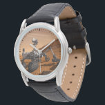 Mars Science Laboratory Curiosity Rover. Horloge<br><div class="desc">Het concept van Mars Science Laboratory Curiosity rover is een mobiele robot die het cadeau van Mars onderzoekt. In dit afbeelding onderzoekt de rover een rots op Mars met een set gereedschappen aan het uiteinde van de arm van de rover, die ongeveer 7 voet uitstrekt. Twee instrumenten op de arm...</div>