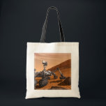 Mars Science Laboratory Curiosity Rover. Tote Bag<br><div class="desc">Het concept van Mars Science Laboratory Curiosity rover is een mobiele robot die het cadeau van Mars onderzoekt. In dit afbeelding onderzoekt de rover een rots op Mars met een set gereedschappen aan het uiteinde van de arm van de rover, die ongeveer 7 voet uitstrekt. Twee instrumenten op de arm...</div>