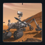 Mars Science Laboratory Curiosity Rover. Vierkante Klok<br><div class="desc">Het concept van Mars Science Laboratory Curiosity rover is een mobiele robot die het cadeau van Mars onderzoekt. In dit afbeelding onderzoekt de rover een rots op Mars met een set gereedschappen aan het uiteinde van de arm van de rover, die ongeveer 7 voet uitstrekt. Twee instrumenten op de arm...</div>