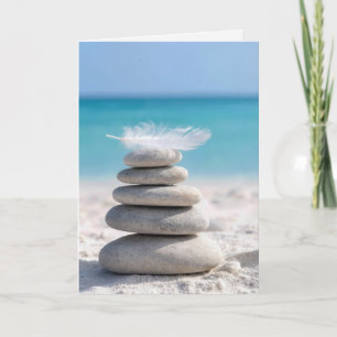 Medeleven witte veer op een strandstenen stapel kaart