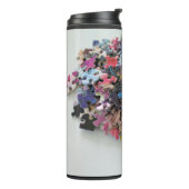 Meerkleurige puzzelstukken op een thermische droog thermosbeker (Gedraaid links)