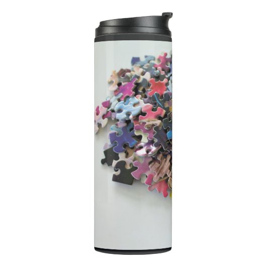 Meerkleurige puzzelstukken op een thermische droog thermosbeker (Gedraaid links)